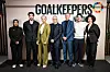 Gruppe mennesker poserer foran Goalkeepers Network-logo på arrangement.