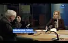 Programleder og gjest sitter ved bord i NRK-radiostudio med mikrofoner.