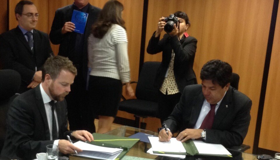 Isaksen signerer avtale med sin kollega i Brasil. (Foto: Dag Rune Olsen, Twitter)