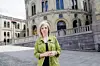 Kvinne står foran Stortinget i Oslo en solrik dag