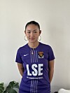 Person i lilla fotballdrakt med Nike-logo og LSE Women’s Football står foran lys vegg.