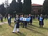 En gruppe demonstranter står på gresset i en park og holder plakater.