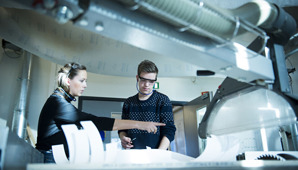Andreårsstudentene Izelin Tujunen og Erik Harmens på produktdesign på Kjeller jobber med å skjære ut treverket til en babyvugge.