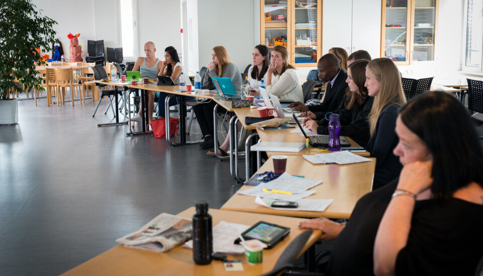 bildet viser studenter samlet i en halvsirkel innendørs