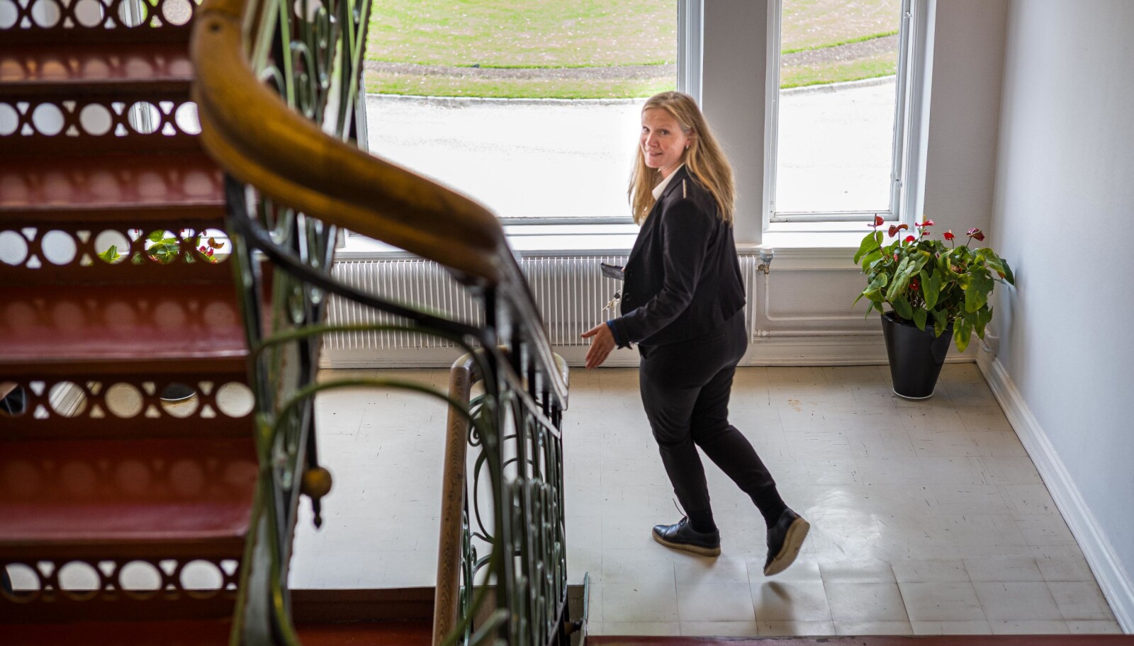 — Jeg ser helt klart noen paralleller mellom de to jobbene, sier Mari Sundli Tveit. Her er hun på vei ned trappen i bygget Circus på campus Ås, hvor hun har kontor. Foto: Siri Øverland Eriksen — Jeg ser helt klart noen paralleller mellom de to jobbene, sier Mari Sundli Tveit. Her er hun på vei ned trappen i bygget Circus på campus Ås, hvor hun har kontor. Foto: Siri Øverland Eriksen
