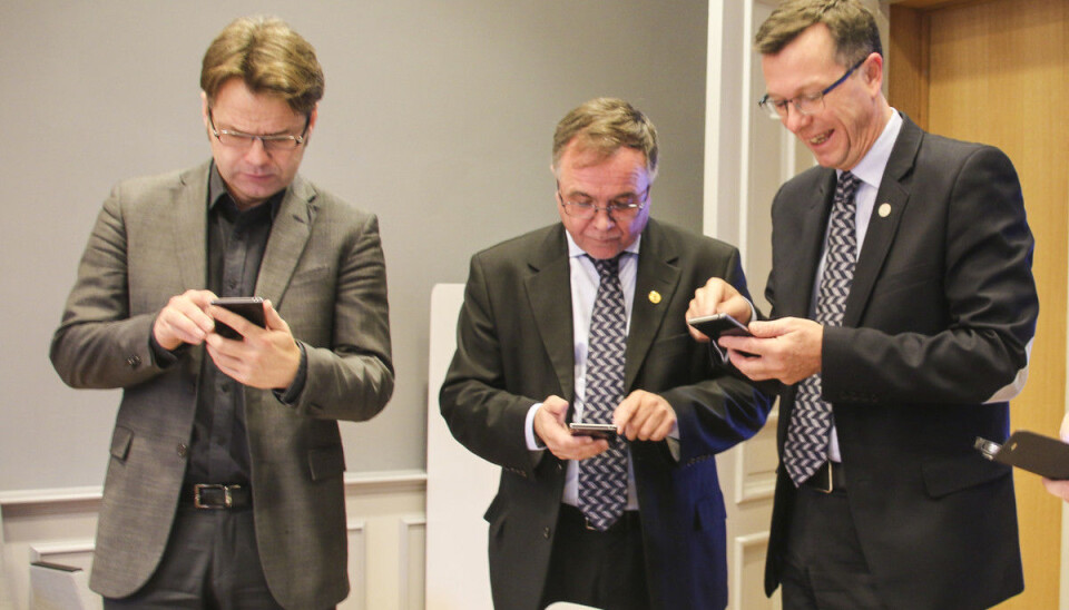 Tre herrar djupt konsentrerte over kvar sin telefon. Måndag skal heile universitetsstyret ved Universitetet i Bergen logga seg på same digitale møte. Dette er assisterande universitetsdirektør Tore Tungodden, universitetsdirektør Kjell Bernstrøm og rektor Dag Rune Olsen.
