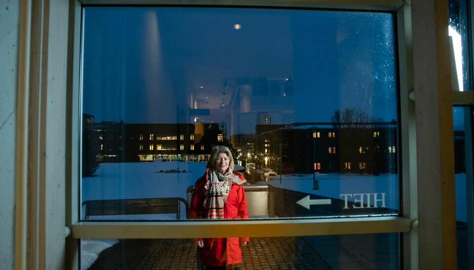 Rektor Anne Husebekk utenfor administrasjonsbygget på UiTs campus i Tromsø. Pilen peker til Hiet, som er navnet på et av rommene i bygget. Foto: Lars Åke Andersen