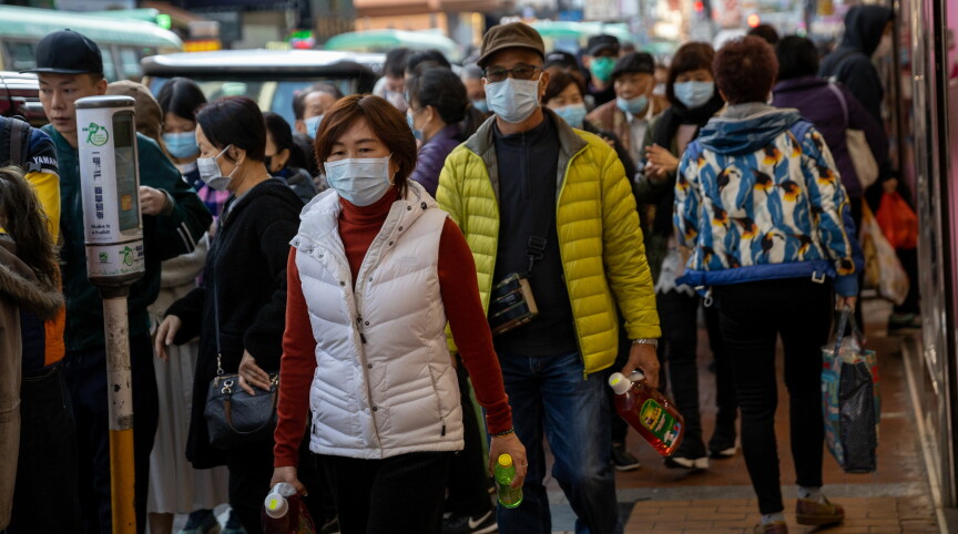 I Hongkong står folk i kø for å få gratis munnbind for å beskytte seg mot det nye coronaviruset. Alle tog og ferger mellom Hongkong og Kina innstilles fra midnatt den 30. januar, opplyser Hongkongs leder Carrie Lam. Foto: NTB-Scanpix - EPA/Jerome Favre