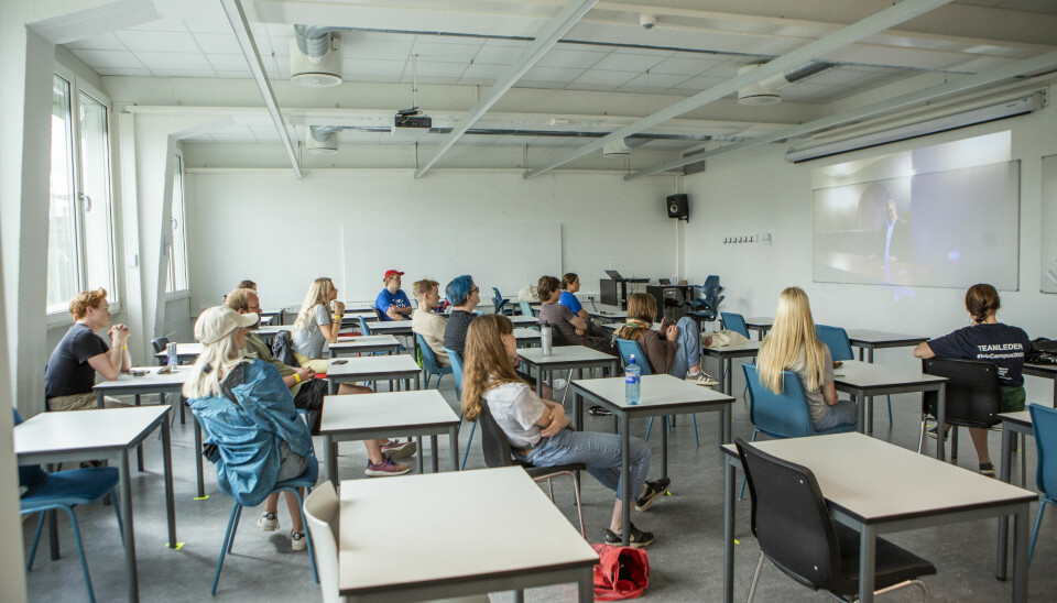 Her fra studiestart i 2020 ved Høyskolen Kristiania. Faddere og studenter følger direktesendt oppstartsseremoni på storskjerm i et klasserom.