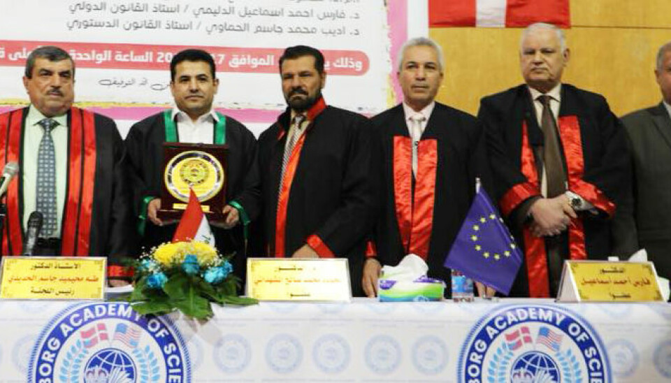 Tidligere innenriksminister Qasim al-Araji (med grønn jakkekant) mottar et master-diplom fra Aalborg Academy of Science - i Irak.