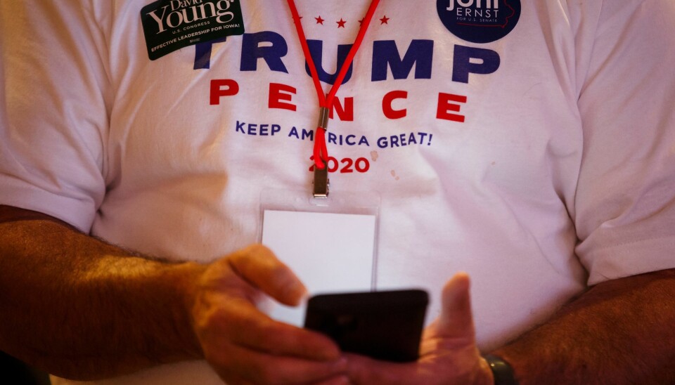 Folk følger med på telefonene mens resultatene kommer inn under en valgvake for republikanerne i Iowa.