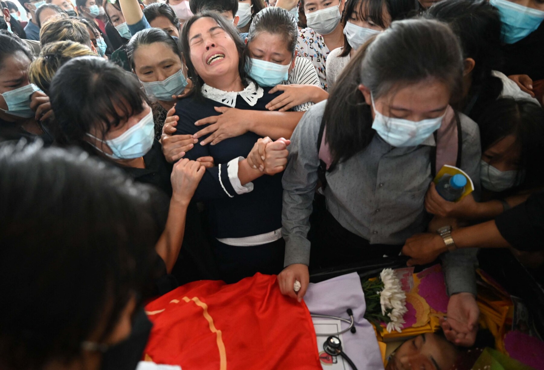 EDITORS NOTE: Graphic content / The mother (C) of Khant Nyar Hein reacts next to his body at the funeral in Yangon on March 16, 2021, after the first year medical student was shot dead during a crackdown by security forces on protesters taking part in a demonstration against the military coup. (Photo by STR / AFP) EDITORS NOTE: Graphic content / The mother (C) of Khant Nyar Hein reacts next to his body at the funeral in Yangon on March 16, 2021, after the first year medical student was shot dead during a crackdown by security forces on protesters taking part in a demonstration against the military coup. (Photo by STR / AFP)