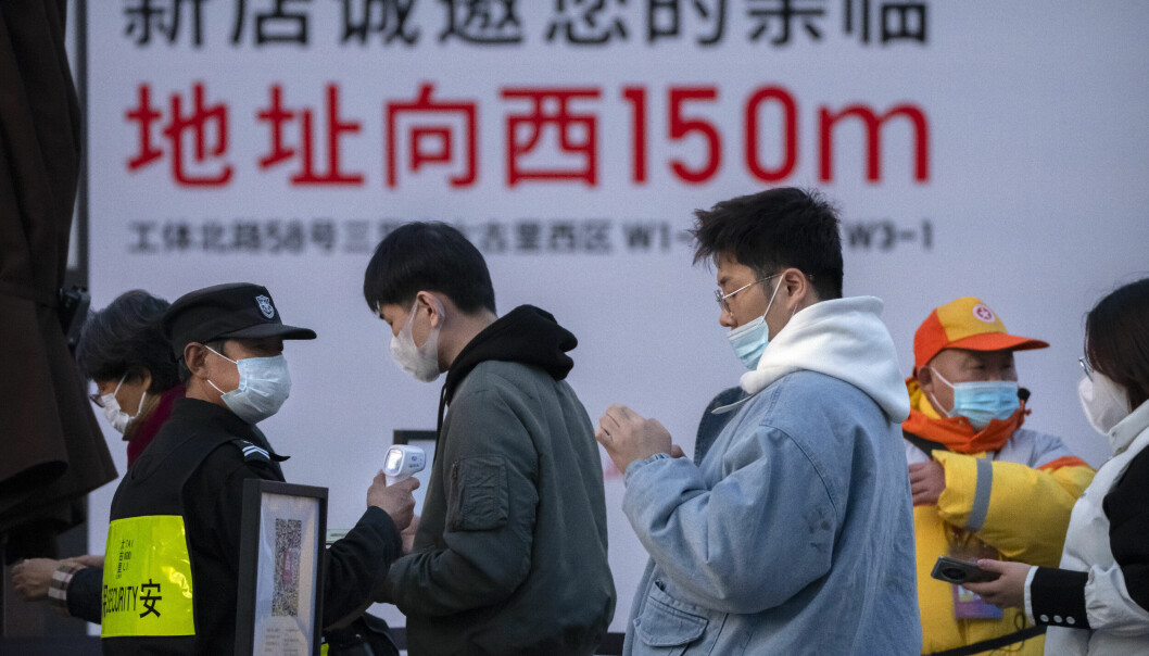 Temperaturmåling og sjekking av koronasertifikat før man kan gå inn på kjøpesenter i Beijing.
