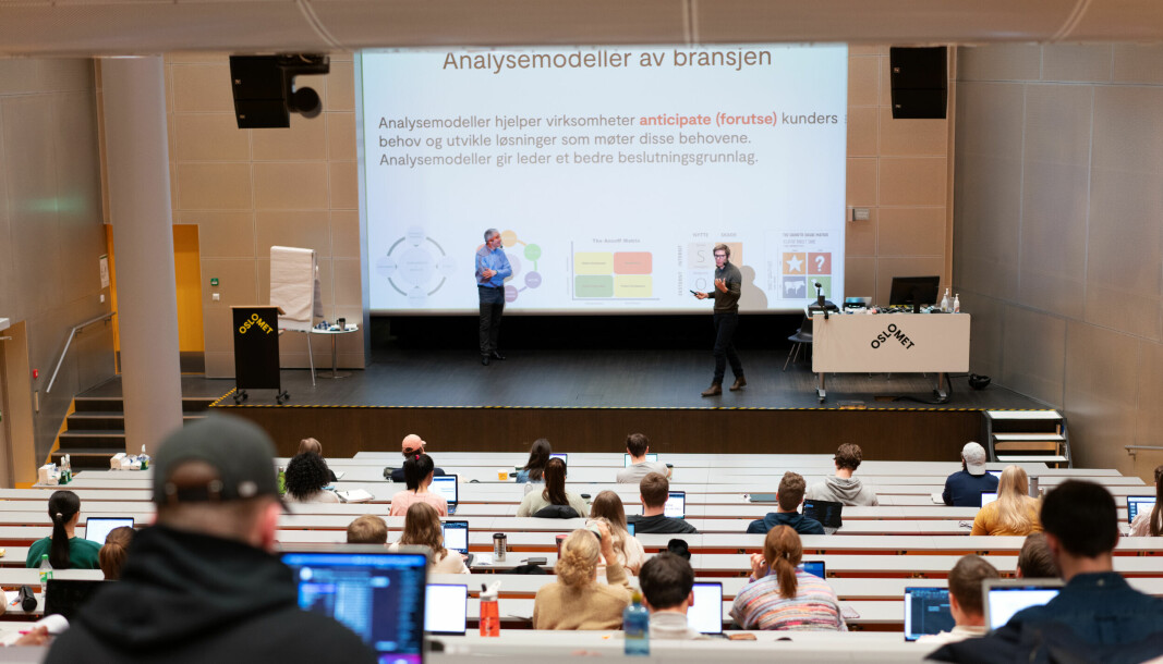 Omtrent 50 studenter møtte opp fysisk til forelesning. På scenen er underviserne Fred Strønen (t.v.) og Even Haug Larsen (t.h.)
