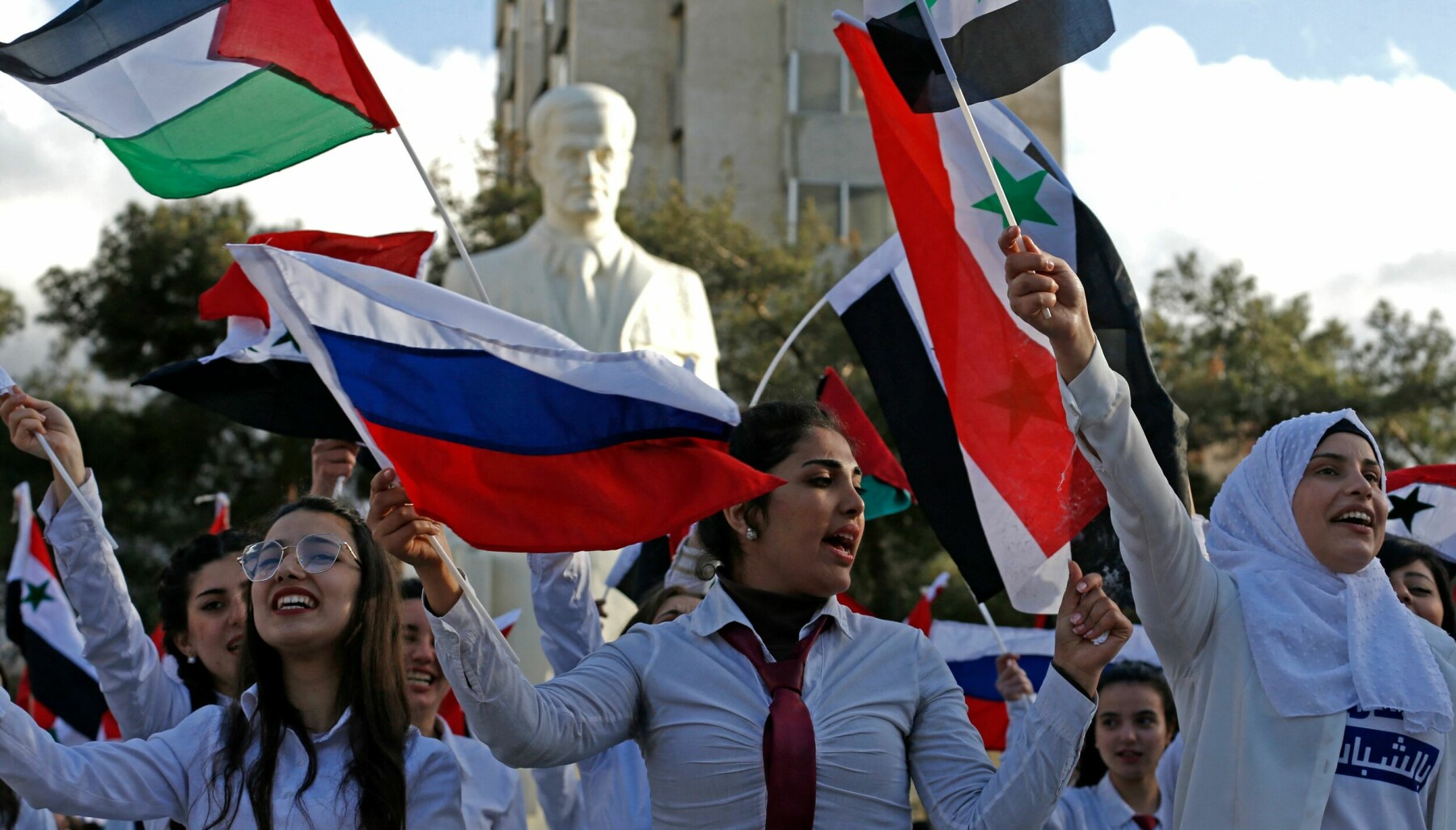 Students wave flags as they gather in support of Russia following the Russian invasion of Ukraine, at the university of Damascus in the Syrian capital, on March 9, 2022. (Photo by LOUAI BESHARA / AFP)