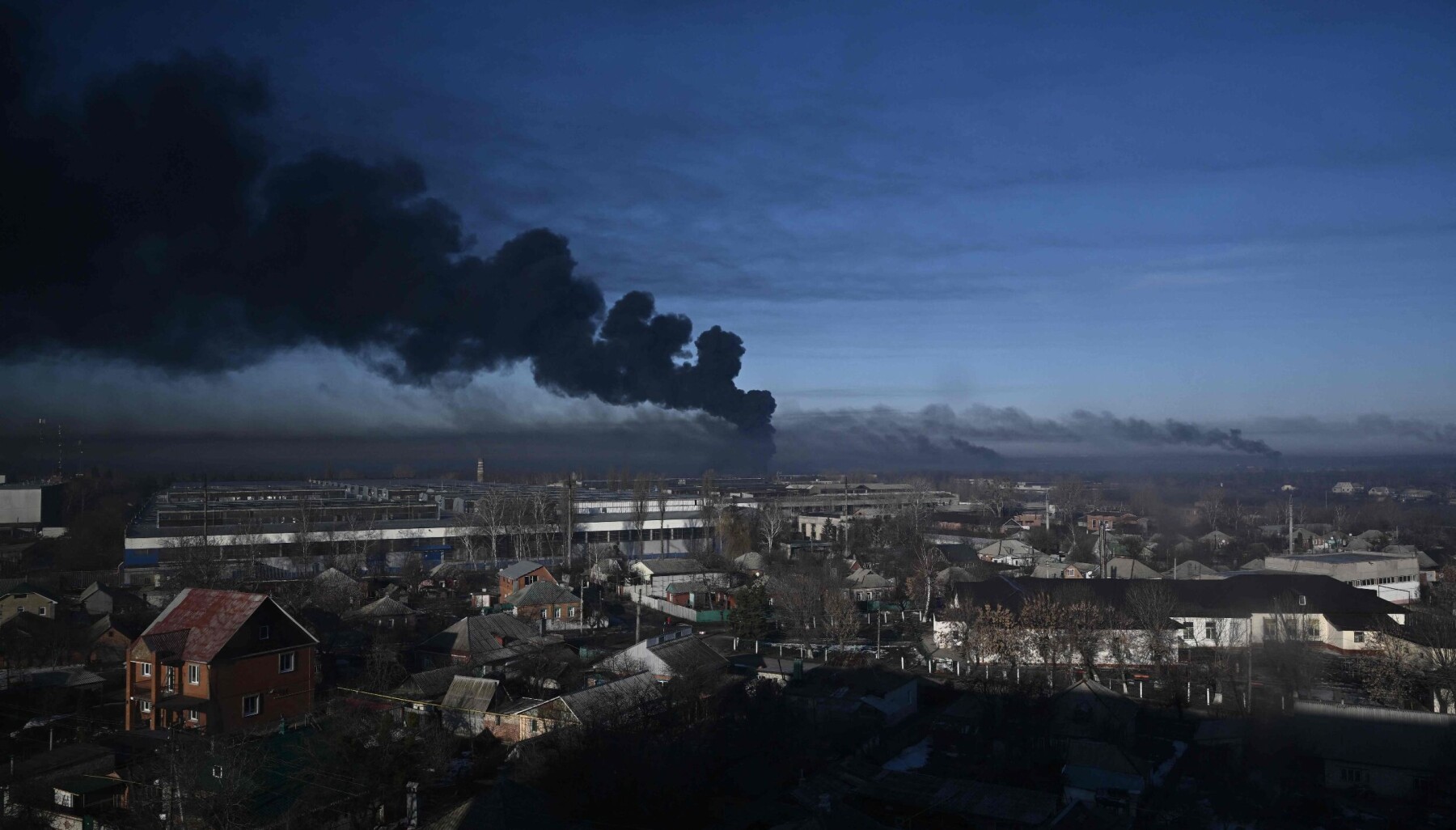 TOPSHOT - Black smoke rises from a military airport in Chuguyev near Kharkiv on February 24, 2022. - Russian President Vladimir Putin announced a military operation in Ukraine today with explosions heard soon after across the country and its foreign minister warning a "full-scale invasion" was underway. (Photo by Aris Messinis / AFP) TOPSHOT - Black smoke rises from a military airport in Chuguyev near Kharkiv on February 24, 2022. - Russian President Vladimir Putin announced a military operation in Ukraine today with explosions heard soon after across the country and its foreign minister warning a "full-scale invasion" was underway. (Photo by Aris Messinis / AFP)
