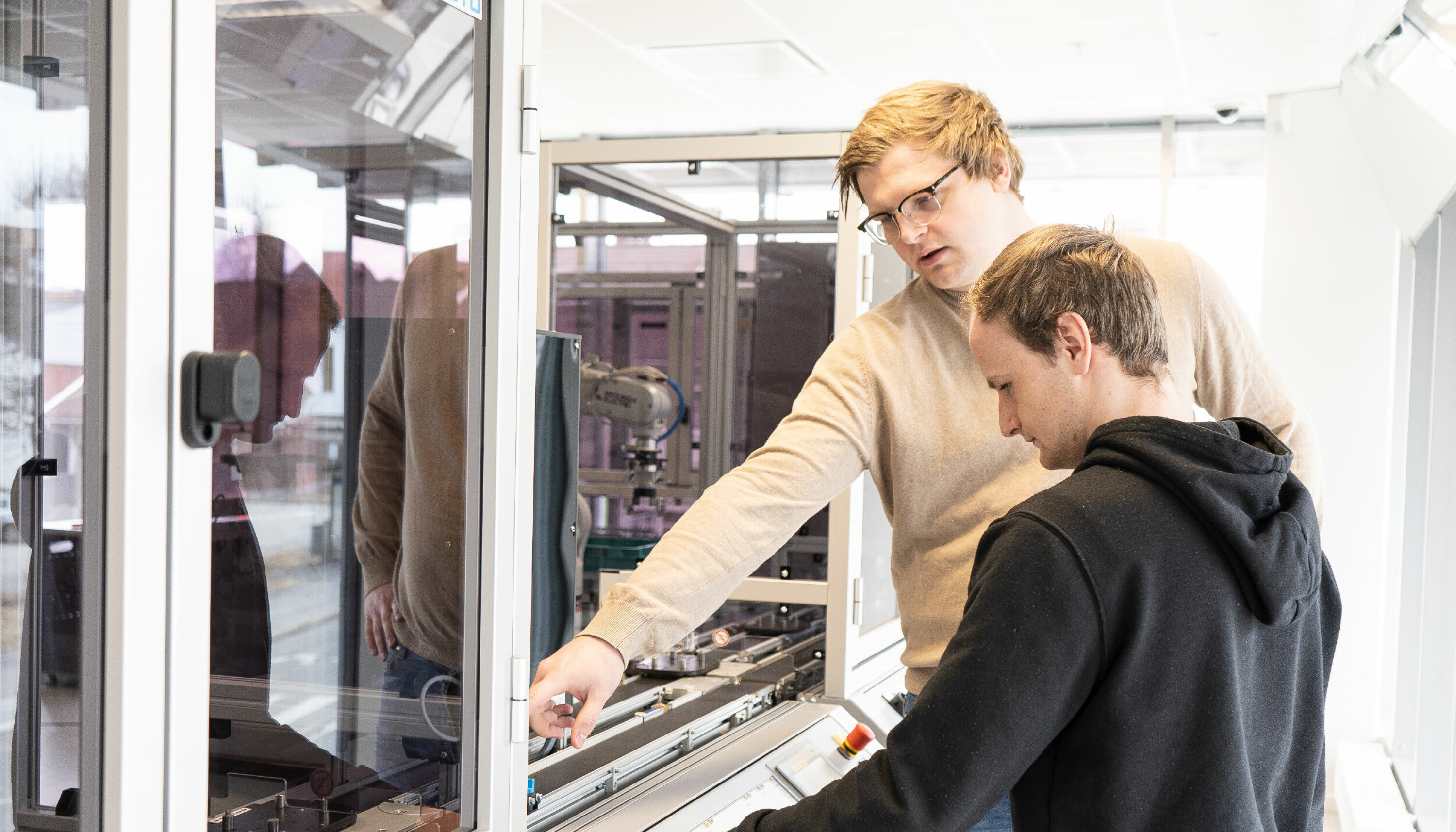 Tobias Sandvik (foran) og Ingvald Hansen viser oss noen av maskinene på labben ved Fagskolen i Viken, Kongsberg.