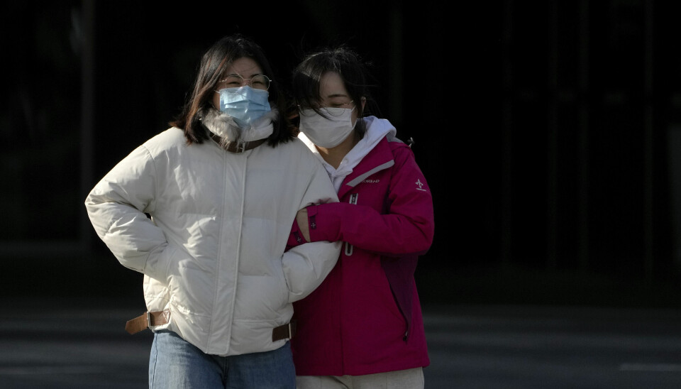 To unge kvinner i Beijing, der gradestokken tirsdag nærmet seg minus 10 grader. Kinesiske myndigheter har besluttet å sende studentene hjem fra en rekke universiteter og innføre fjernundervisning og digitale eksamener.