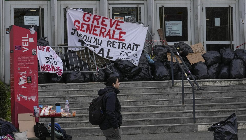 En student går forbi den blokkerte inngangen til Université Paris Nanterre fredag.