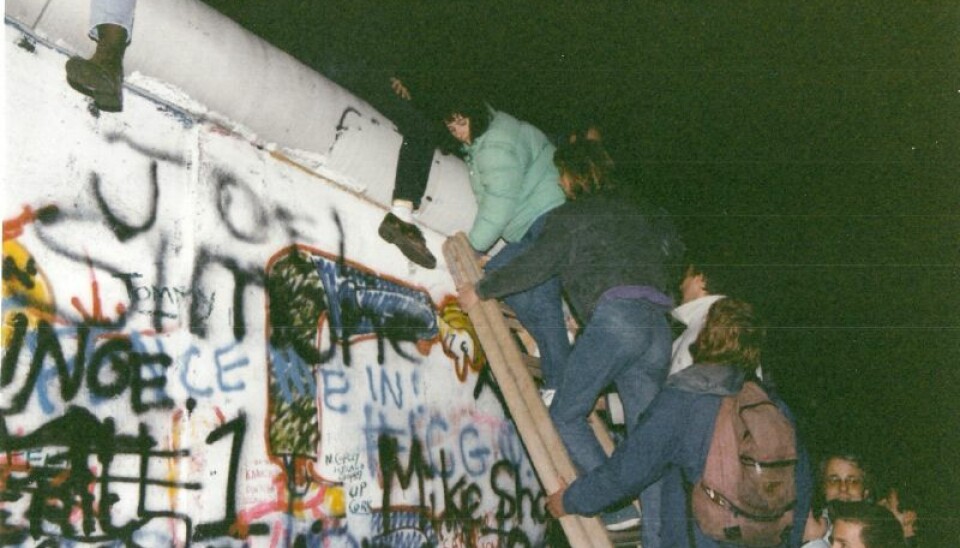 Vesttyskere klatrer opp på Berlinmuren i dens siste dager. Hvilkket år? Mennesker klatrer opp på Berlinmuren i november 1989.