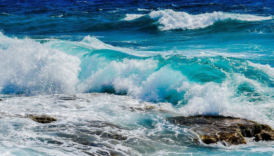 Høye bølger som slår mot store svaberg.