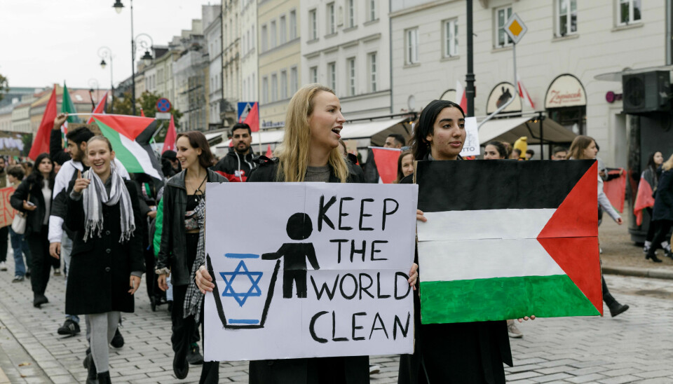 Demonstrasjonstog med palestinsk flagg og plakat med tekstem Kepp the world clean