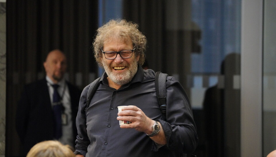 Frederic Hauge smiler med en kaffekopp i hånden.