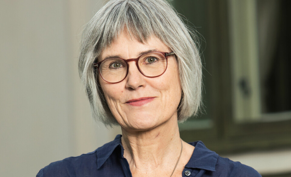 Mette Halskov Hansen, viserektor ved Universitetet i Oslo. Hun har grått mellomlangt hår og briller, og en blå skjorte på seg. Portrettfoto.