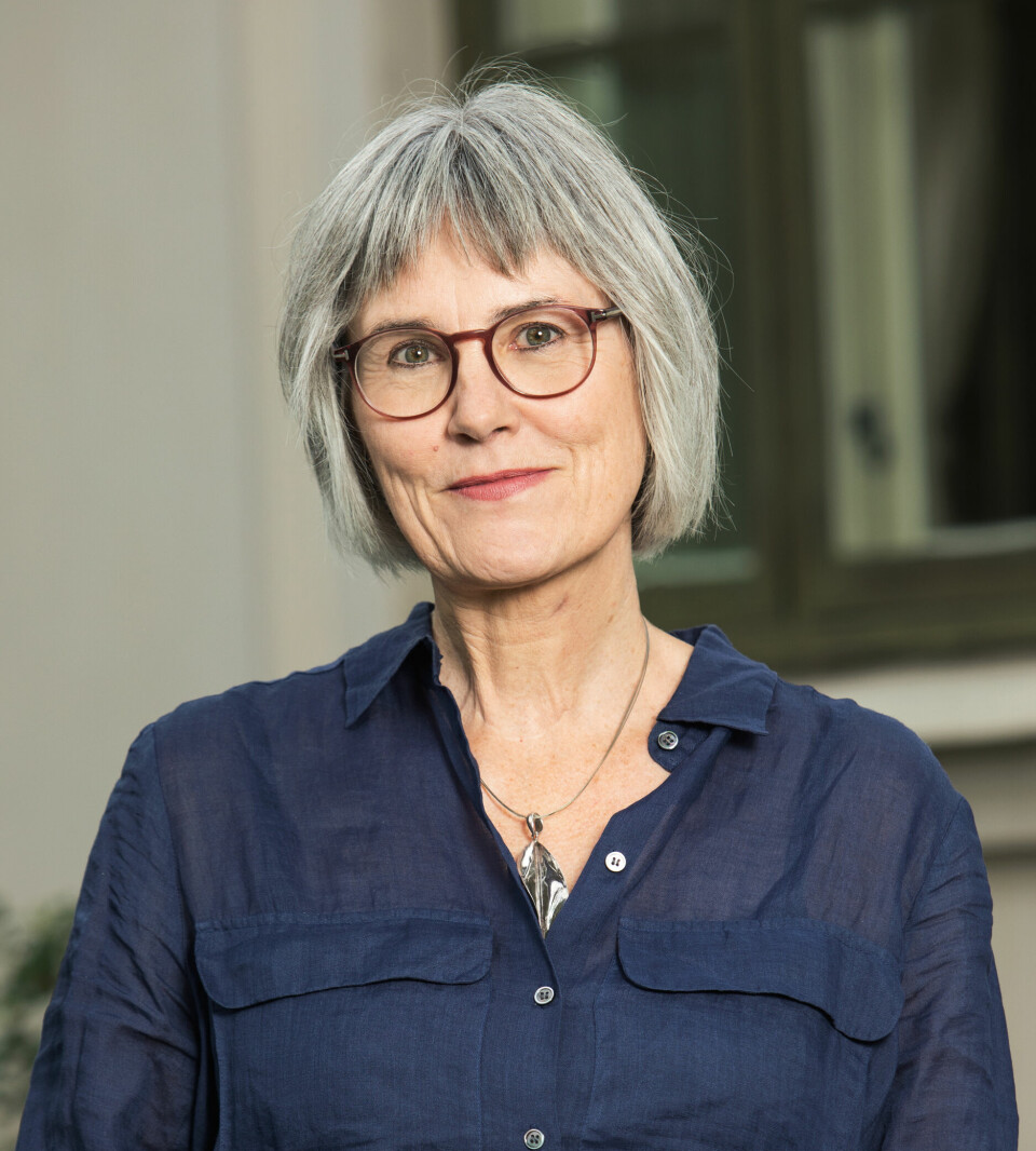 Mette Halskov Hansen, viserektor ved Universitetet i Oslo. Hun har grått mellomlangt hår og briller, og en blå skjorte på seg. Portrettfoto.