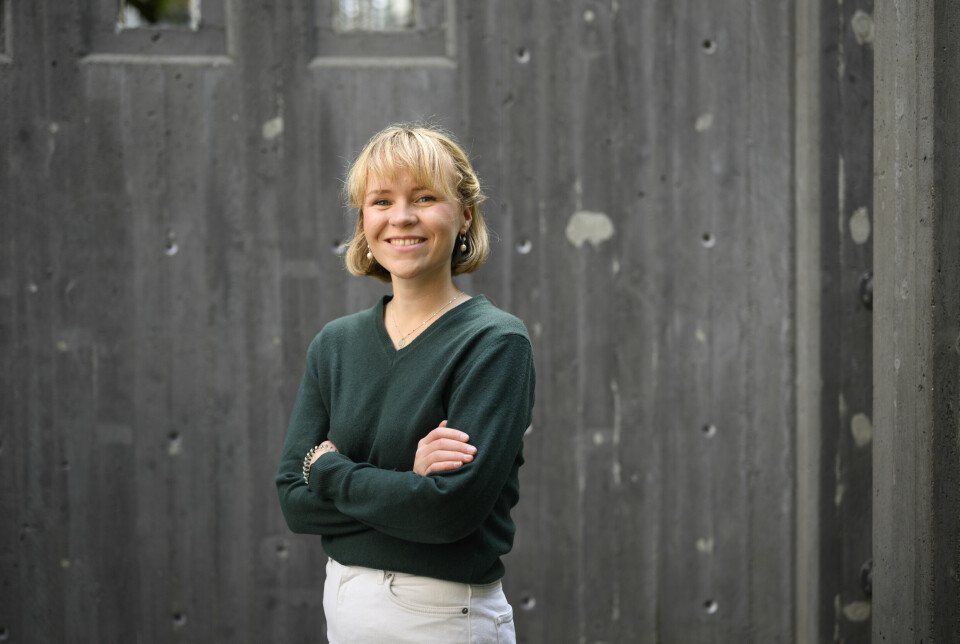 Portrett av Oline Sæther foran murvegg