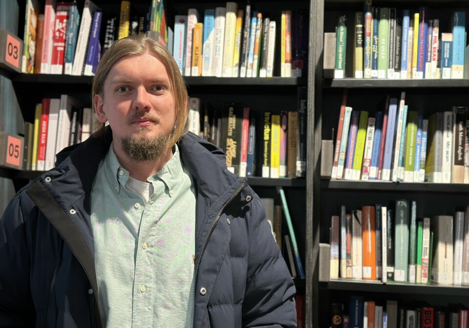 Jakob Jensen Høiberg Lerheim er leder for Nevrodivergent Studentforening. Han er en mann med blondt halvtlangt hår og skjegg, og står foran en bokhylle.
