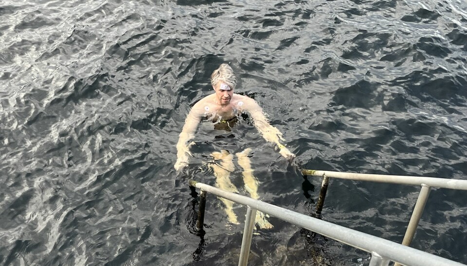 Bildet viser en mann som bader i sjøen, i mars måned.