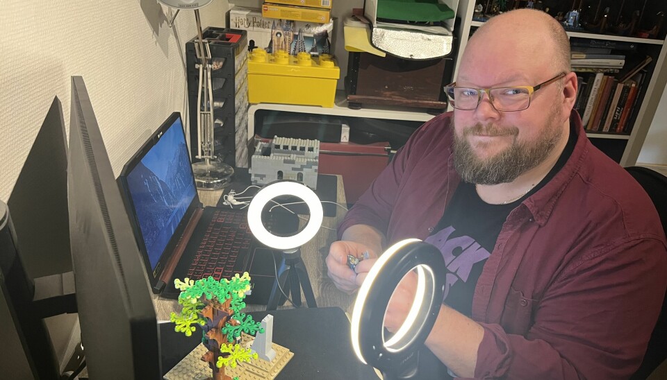 Bildet viser en voksen mann med briller som bygger med legoklosser