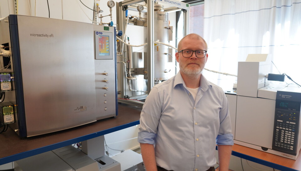 Hvordan skal kjemifaget sette kurs mot bedre tider? Stian Svelle, professor og instituttleder på Kjemisk institutt ved Blindern, ser fremover. Instituttleder i blå skjorte står foran et instrument på labben