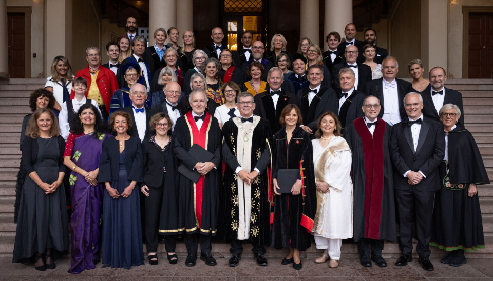 Rektorat, ledelse og dekaner sammen med nyutnevnte æresdoktorer og pris- og medaljevinnere utenfor Universitetets aula. Stor festkledd forsamling på trappene foran Universitetets Aula