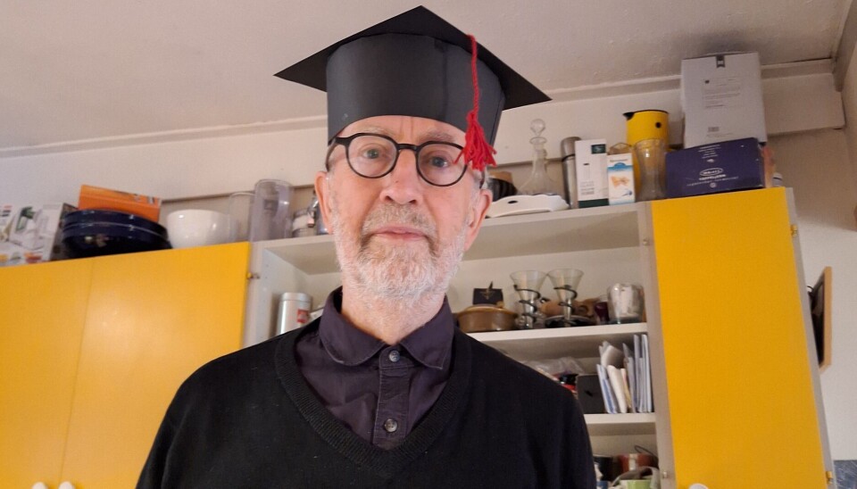 Som en del av undervisningen i Global politisk økonomi valgte førsteamanuensis Peter Stuart Robinson å brenne en replika av den tradisjonelle hatten som gis til nyslåtte doktorer. Dette som en protest mot det han mener er en markedsretting av universitetet. Bilde av Peter Stuart Robinson med hatt.