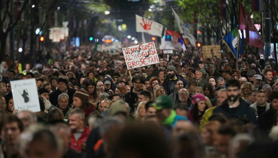 En demonstrant holder en plakat hvor det står skrevet: Jeg er ikke en student, men jeg kan gå. Demonstrasjonene mot den serbiske regjeringen har vart i seks måneder. Her fra Beograd den 31. mars 2025. Studentdemonstrasjonene i Serbia samler tusenvis i gatene.