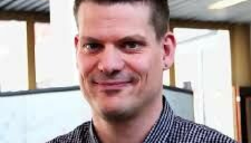 Stian Husemoen sier at NTNU ikke har greid å finne ut hvem svindlerne er. Portrett av en mann. Han har kort, mørkt hår og smiler.