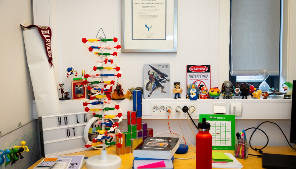 Figurer fra forskjellige spill, en Tetris-lampe, en fargerik DNA-modell og en vimpel fra Harvard. Beate W. Hygen sitt kontor detaljbilde.