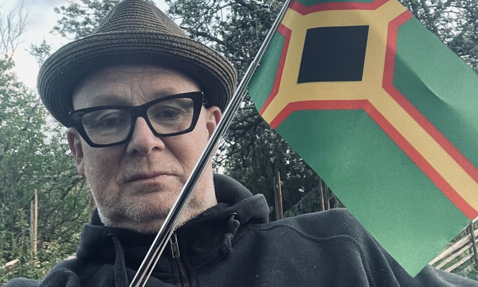 — Det er en rørende stolthet over de skogfinske røttene nå, sier Tor Einar Bjørnhullet Bekken. Her vifter han med skogfinnenes flagg. Mann vifter med et skogfinsk flagg, Det er grønt i bunn med et mønster i svart, gult og rødt